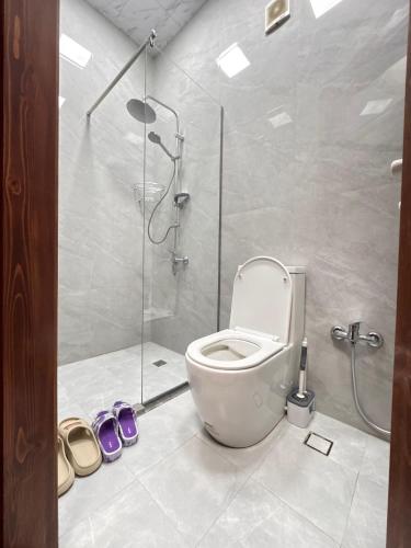 a bathroom with a shower with a toilet and shoes at Bag Evi - Villa in Quba