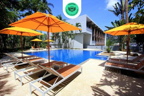 a group of chairs with umbrellas next to a pool at Marina Express-Fisherman Aonang in Ao Nang Beach