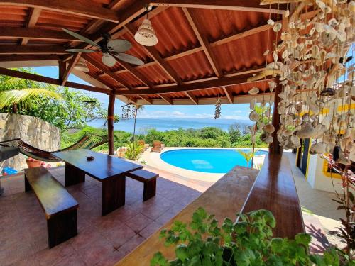 an outdoor patio with a table and a pool at Roma del mar - Vila s bazénem a krásným výhledem na moře in Paquera