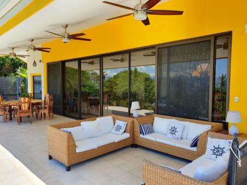 an outdoor patio with two couches and a table at Roma del mar - Vila s bazénem a krásným výhledem na moře in Paquera