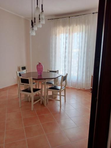 a dining room table with chairs and a vase on it at Casa Karmel in Campofelice di Roccella