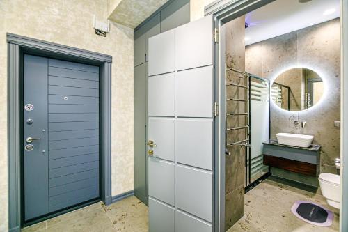 La salle de bains est pourvue d'une porte bleue et d'un lavabo. dans l'établissement Panorama Residence Sea View Apartment by Baku Housing, à Baku