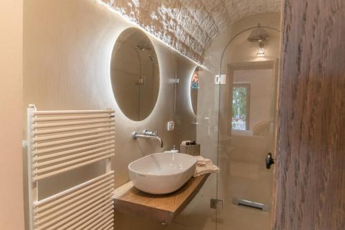 a bathroom with a bowl sink and a shower at CANTALANOTTE Luxury Trulli Resort in Cisternino