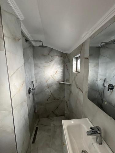 a white bathroom with a sink and a shower at Hotel Restorant Halal Il Tramonto. in Vorë