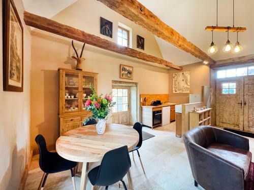 une cuisine et une salle à manger avec une table et des chaises en bois dans l'établissement Petite maison rurale, à Anlhiac