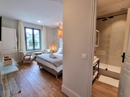 a bedroom with a bed and a bathroom with a shower at La Villa des Tendances in Soissons