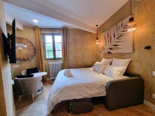 a bedroom with a bed and a desk and a window at La Villa des Tendances in Soissons