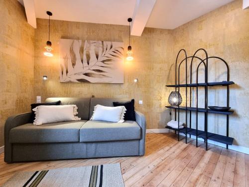 a living room with a couch and shelves at La Villa des Tendances in Soissons