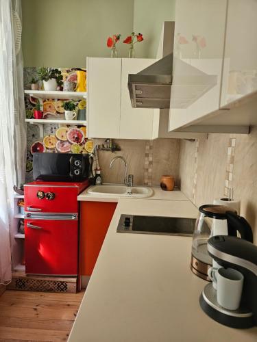 a kitchen with white cabinets and a red refrigerator at Libau Baden apartamenti in Liepāja