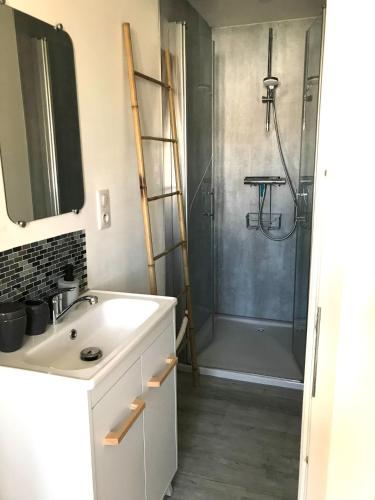 une salle de bain avec un lavabo et une douche dans l'établissement Maisonnette à 30 mètres de la plage, à Saint-Denis-dʼOléron