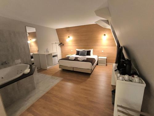 a bedroom with a bed and a bathroom with a sink at Douro Marina Hotel & SPA in Resende