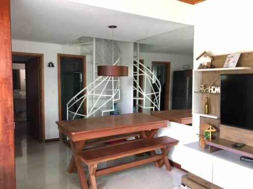 ein Wohnzimmer mit einem Holztisch und einem TV in der Unterkunft Bangalô monte castelo in Sairé