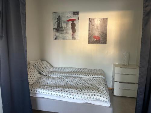 a bedroom with a bed and two pictures on the wall at "Nitton" loistava sijainti Tammisaaren keskustassa in Ekenäs