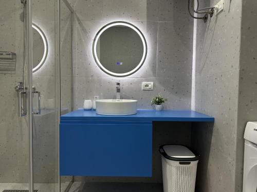 a bathroom with a blue sink and a mirror at LARIMAR Lungomare Vlore in Vlorë