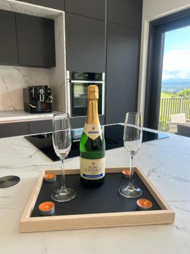 a bottle of champagne and two wine glasses on a tray at Penthaus am Südhang in Velden am Wörthersee