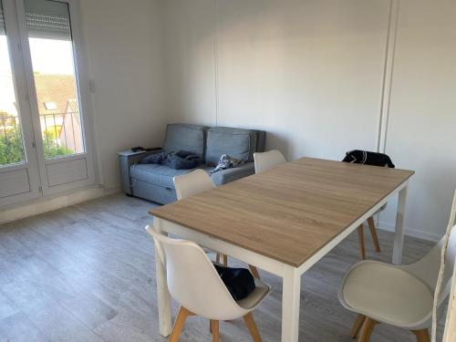 une salle à manger avec une table, des chaises et un canapé dans l'établissement 24h Le Mans, au Mans