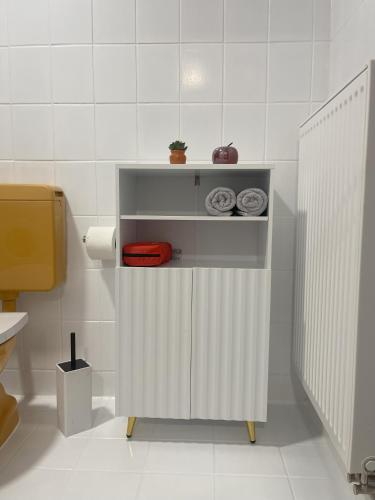 a white bathroom with a shelf with towels on it at Schwarzwald-Idylle in Schonach in Schonach