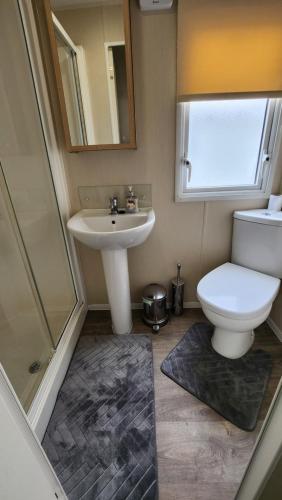 a bathroom with a toilet and a sink and a shower at Citadin Solay in Chestfield