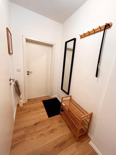 a hallway with a mirror on the wall and a chair at Maisonette-Apartment mit Klimaanlage - in Dorsten Zentrum - in Dorsten