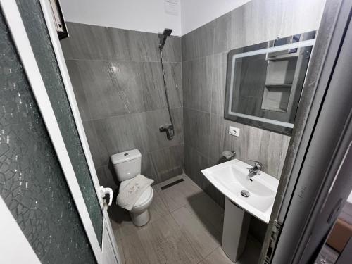 a small bathroom with a toilet and a sink at Vila Roel in Vlorë