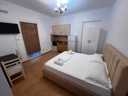 a bedroom with a large bed and a kitchen at Vila Roel in Vlorë