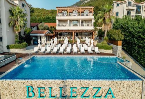 a swimming pool with lounge chairs and a hotel at The Bayview apartment in Donji Morinj