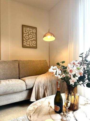a living room with a couch and a table with a bottle of wine at The Bayview apartment in Donji Morinj