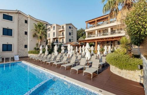 a hotel with a swimming pool with lounge chairs and a hotel at The Bayview apartment in Donji Morinj