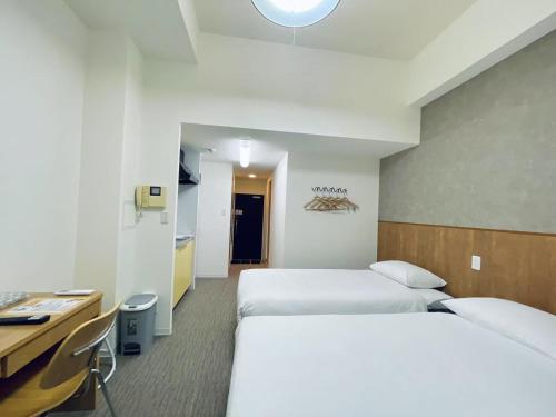 a hotel room with two beds and a desk at 嵐 Arashi BNB 大国町 No8113 in Osaka