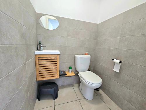 une salle de bain avec toilettes, lavabo et miroir dans l'établissement T3 cosy 200m de la plage, terrasse, parking, au Barcarès