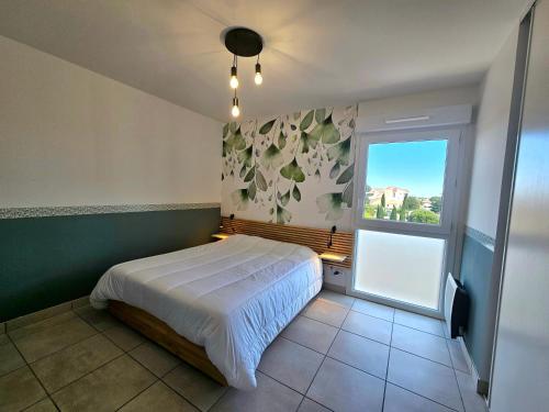 une chambre avec un grand lit et une fenêtre dans l'établissement T3 cosy 200m de la plage, terrasse, parking, au Barcarès