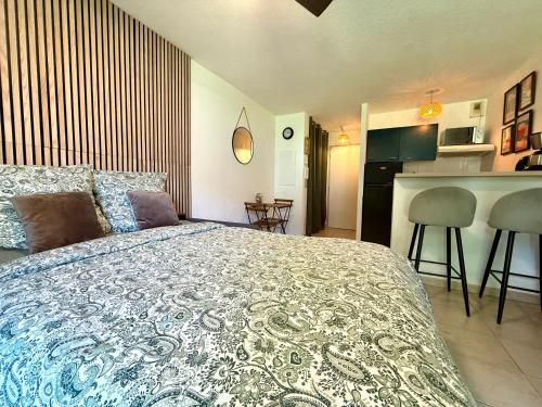 une chambre avec un grand lit et une cuisine dans l'établissement Lum'Arles, à Arles