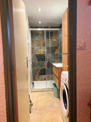 une salle de bain avec douche et machine à laver dans l'établissement Gite au Capitou, à Fréjus
