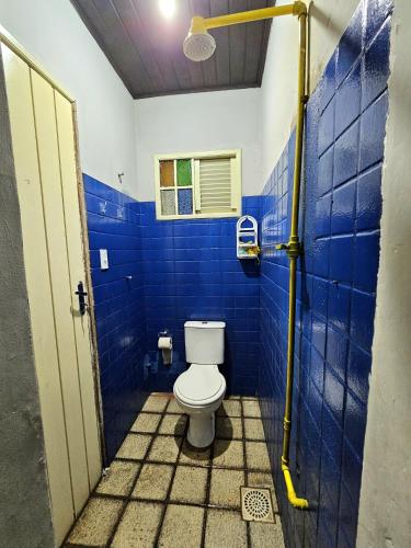 a bathroom with a toilet in a blue tiled wall at Hostel do Seu Tico in São Luís