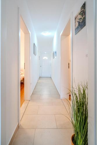 a hallway with white walls and a tile floor at Apartman Elephant in Postira