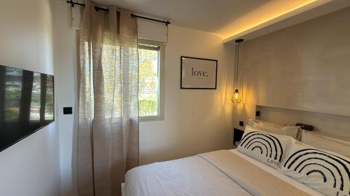 a bedroom with a bed and a window at Romance Marine , face à la mer in Villeneuve-Loubet