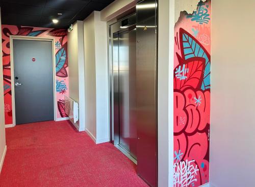 a hallway with a red carpet and colorful walls at Best Western 11BAUER Paris Saint-Ouen in Saint-Ouen