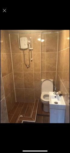 a bathroom with a toilet and a sink at Luxurious Apartments at Beech Grove in Halifax