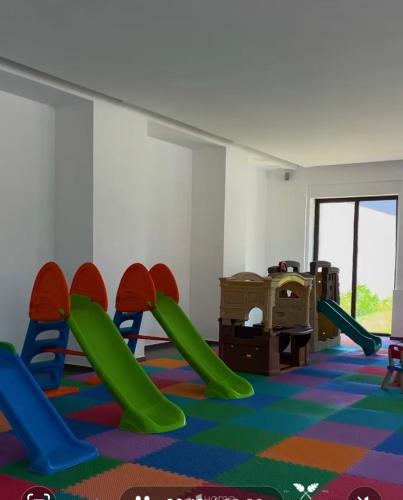 a childrens play room with green slides and chairs at Disfruta a lo grande en la Isla Residences Acapulco in Acapulco