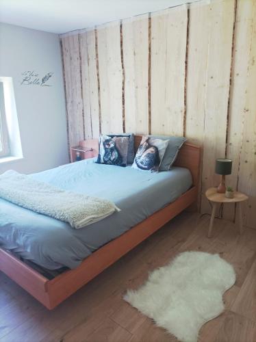 - une chambre avec un lit doté de draps bleus et d'un tapis dans l'établissement Le refuge de la source, à Bussang
