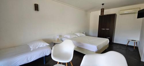 une chambre avec deux lits, une table et des chaises dans l'établissement Studio Dolce & Vita B2 avec piscine et terrasse, à Propriano