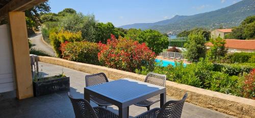 une table bleue et des chaises sur une terrasse avec vue dans l'établissement Studio Dolce & Vita B2 avec piscine et terrasse, à Propriano