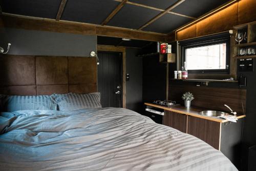 a bedroom with a large bed and a sink at Panoramahytte med utsikt mot Eggenipa in Egge