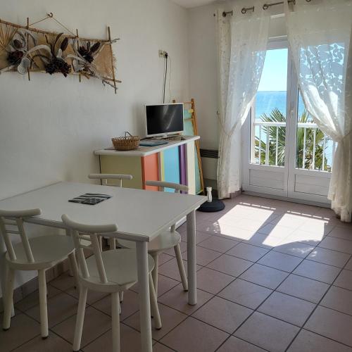 une salle à manger avec une table et des chaises et une fenêtre dans l'établissement STUDIO Les pieds dans l'eau CAP-COZ Fouesnant, à Fouesnant
