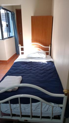 a bedroom with a bed with a blue blanket at UNIVERSIDAD LATINA GUEST HOUSE CASA DE HUESPEDES a in Mexico City