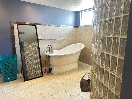 a bathroom with a tub and a glass wall at Lake Francis Lily Pad in Lake Placid