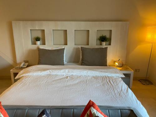 a bedroom with a large bed with two pictures on the wall at Cozy studio in Azzurra Resort Sahl Hasheesh 65 Sq M in Hurghada