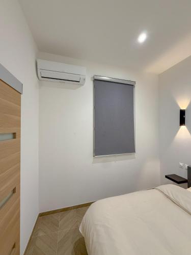 une chambre blanche avec un lit et une fenêtre dans l'établissement T2 luxe 100m Port 2Toulon Clim Wifi fibre SmartTV, à Toulon