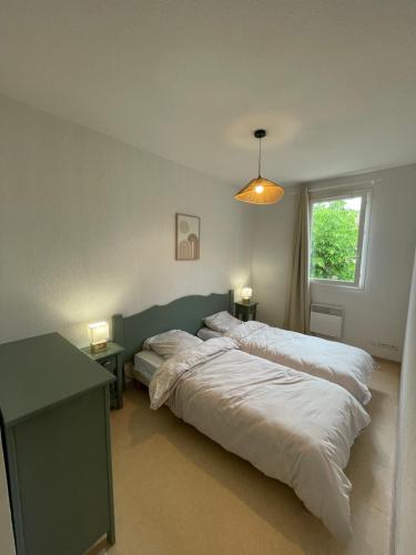 une chambre avec deux lits et une table et une fenêtre dans l'établissement Maison aux Demeures du Ventoux, à Aubignan