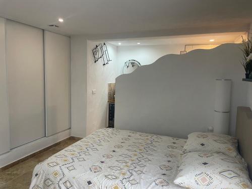 une chambre avec un lit et un mur blanc dans l'établissement Appartement au calme et belle terrasse, à Peyroules